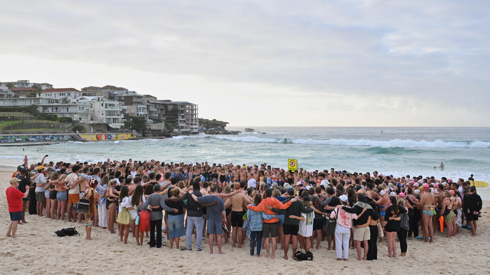 Schwimmer versammeln sich in Sydney zu einer morgendlichen Mahnwache nach der Schießerei am Bondi Beach. Schwimmer versammeln sich in Sydney zu einer morgendlichen Mahnwache nach der Schießerei am Bondi Beach.