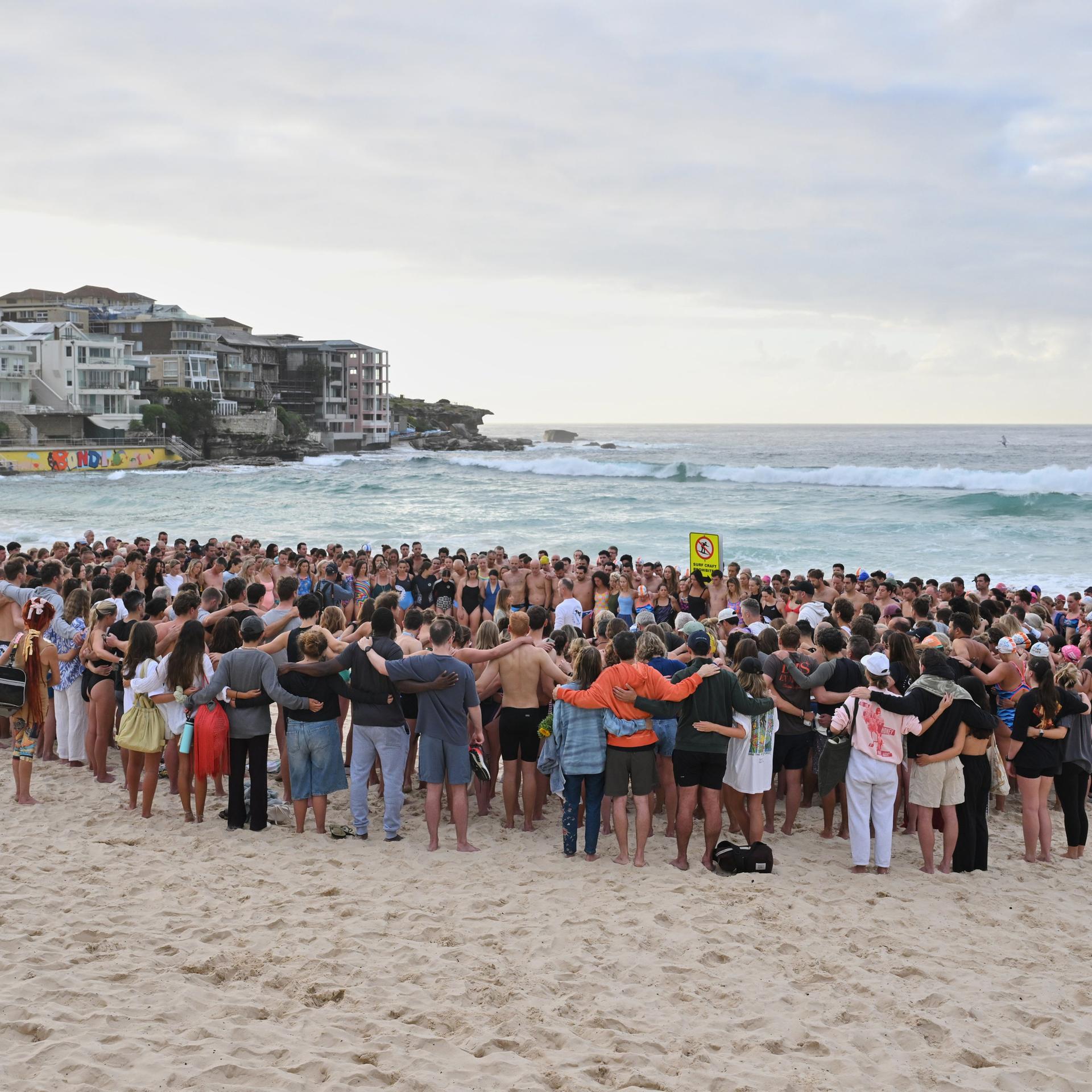 Schwimmer versammeln sich in Sydney zu einer morgendlichen Mahnwache nach der Schießerei am Bondi Beach.