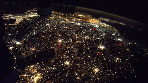 Europa (Aufnahme von der ISS) ist bei Nacht ein einziger Lichterteppich – mit den Anfangsbuchstaben sind Hamburg, Berlin, Nürnberg und das Ruhrgebiet markiert. Sieht es am Samstag dunkler aus? 