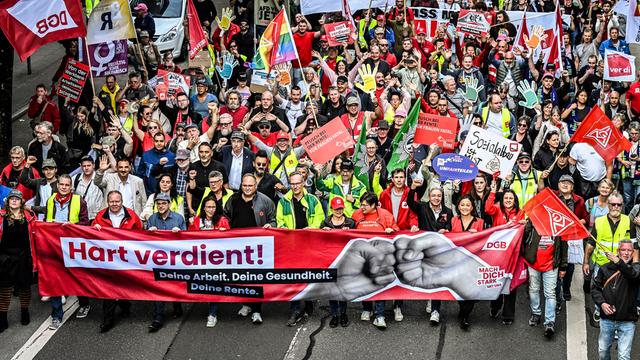 Tausende Demonstranten stehen dicht gedrängt auf einer Straße. Sie tragen Plakate und Fahnen.