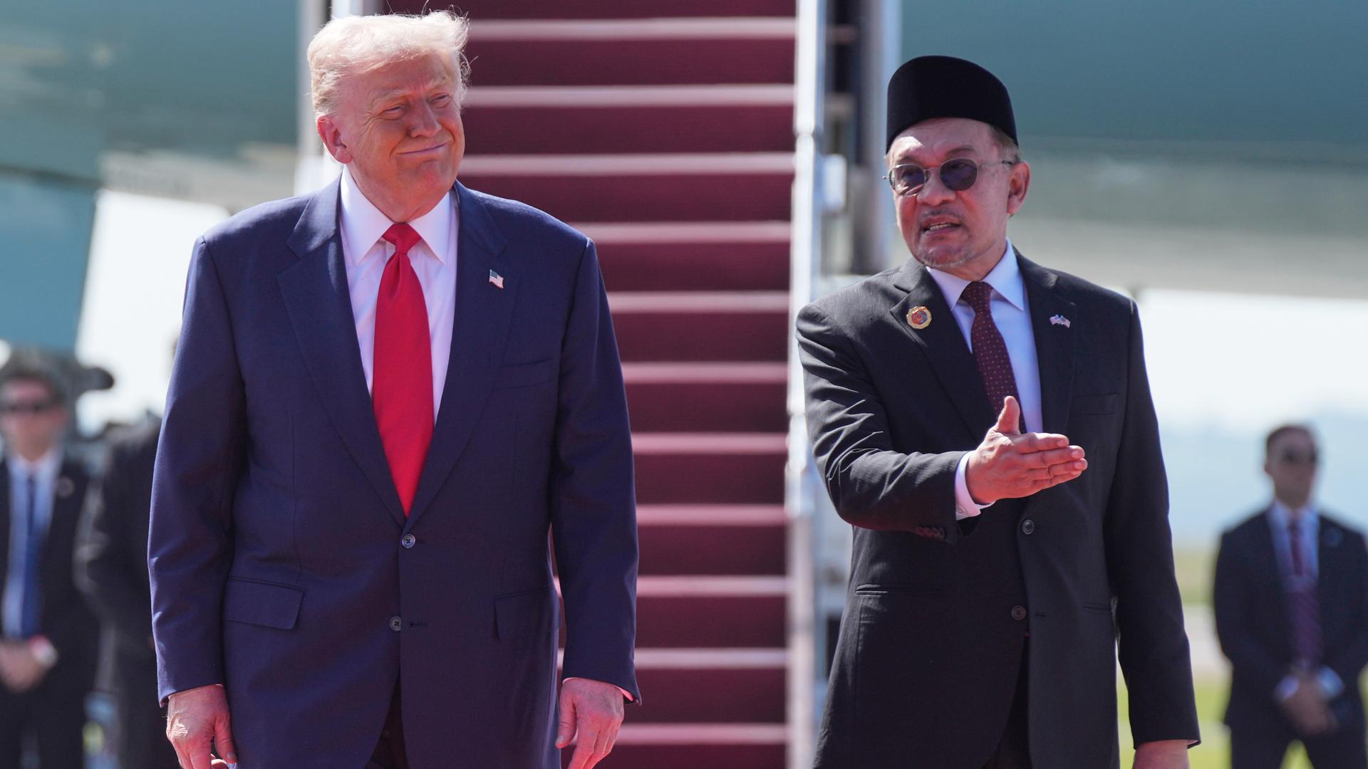 US-Präsident Donald Trump wird vom malaysischen Premierminister Anwar Ibrahim bei seiner Ankunft am internationalen Flughafen Kuala Lumpur begrüßt.  US-Präsident Donald Trump wird vom malaysischen Premierminister Anwar Ibrahim bei seiner Ankunft am internationalen Flughafen Kuala Lumpur begrüßt.
