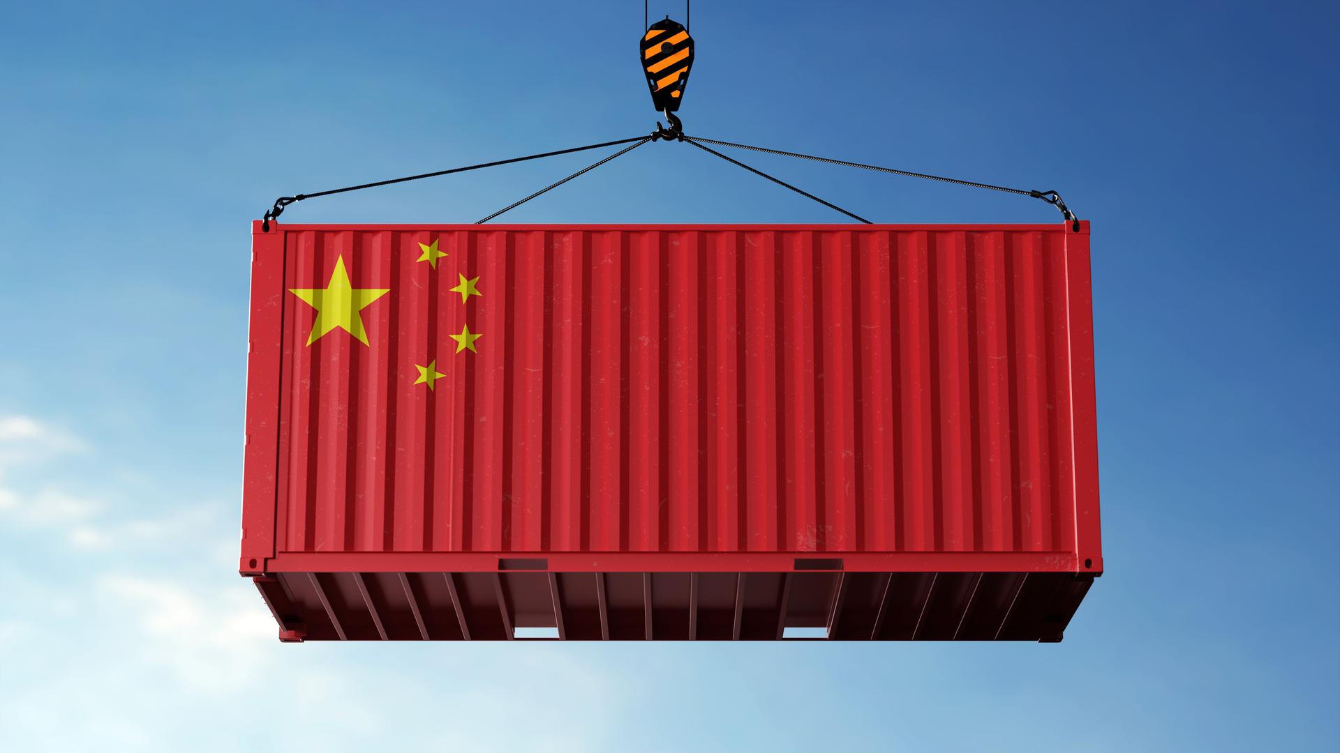 Ein roter Frachtcontainer mit der chinesischen Flagge bedruckt vor blauem Himmel.