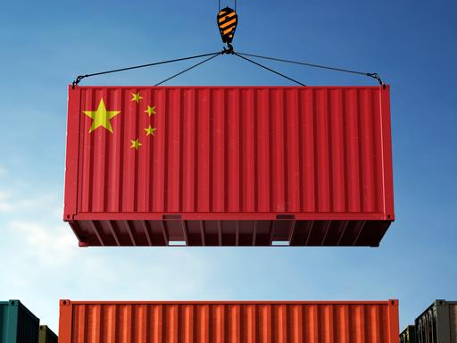 Ein roter Frachtcontainer mit der chinesischen Flagge bedruckt vor blauem Himmel. Ein roter Frachtcontainer mit der chinesischen Flagge bedruckt vor blauem Himmel.