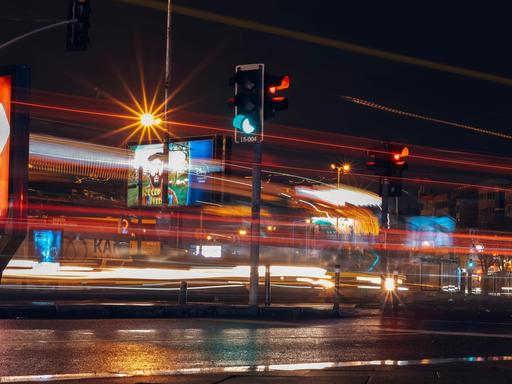 Stadt bei Nacht, eine Straßenbahn fährt über eine Straße