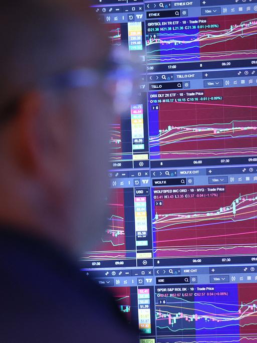 Ein Trader an der New Yorker Börse beobachtet einen Bildschirm mit mehreren Aktienindexen.