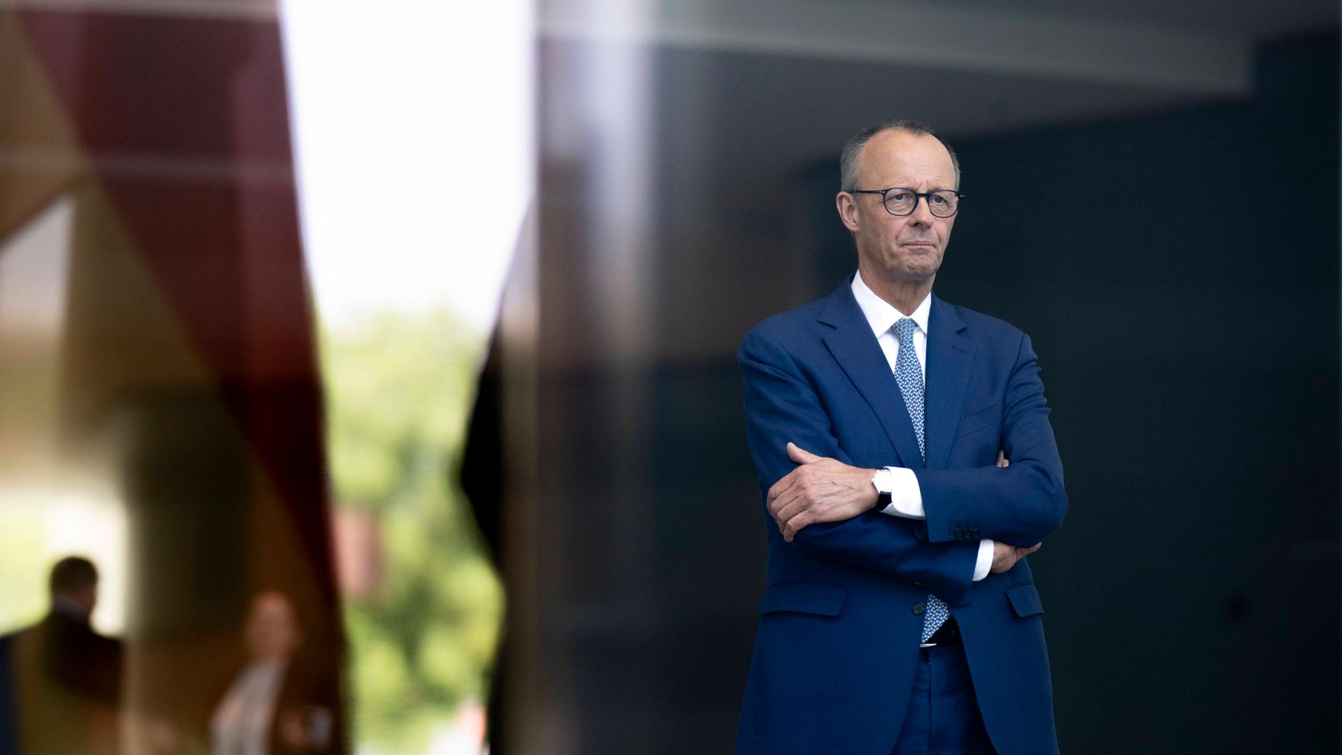 Bundeskanzler Friedrich Merz (CDU) mit ernstem Blick in die Ferne und verschränkten Armen im Foyer des Bundeskanzleramtes in Berlin (11.06.2025)
