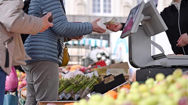 Eine Frau erhält Rückgeld an einem Marktstand auf dem Leipziger Markt. Steigende Preise und die Entwicklung der Inflation belasten viele Verbraucher im Alltag. 