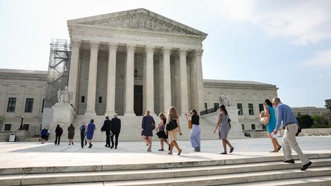Menschen gehen eine Treppe hoch und in das weiße Gerichtsgebäude des Obersten Gerichtshofs in den USA hinein