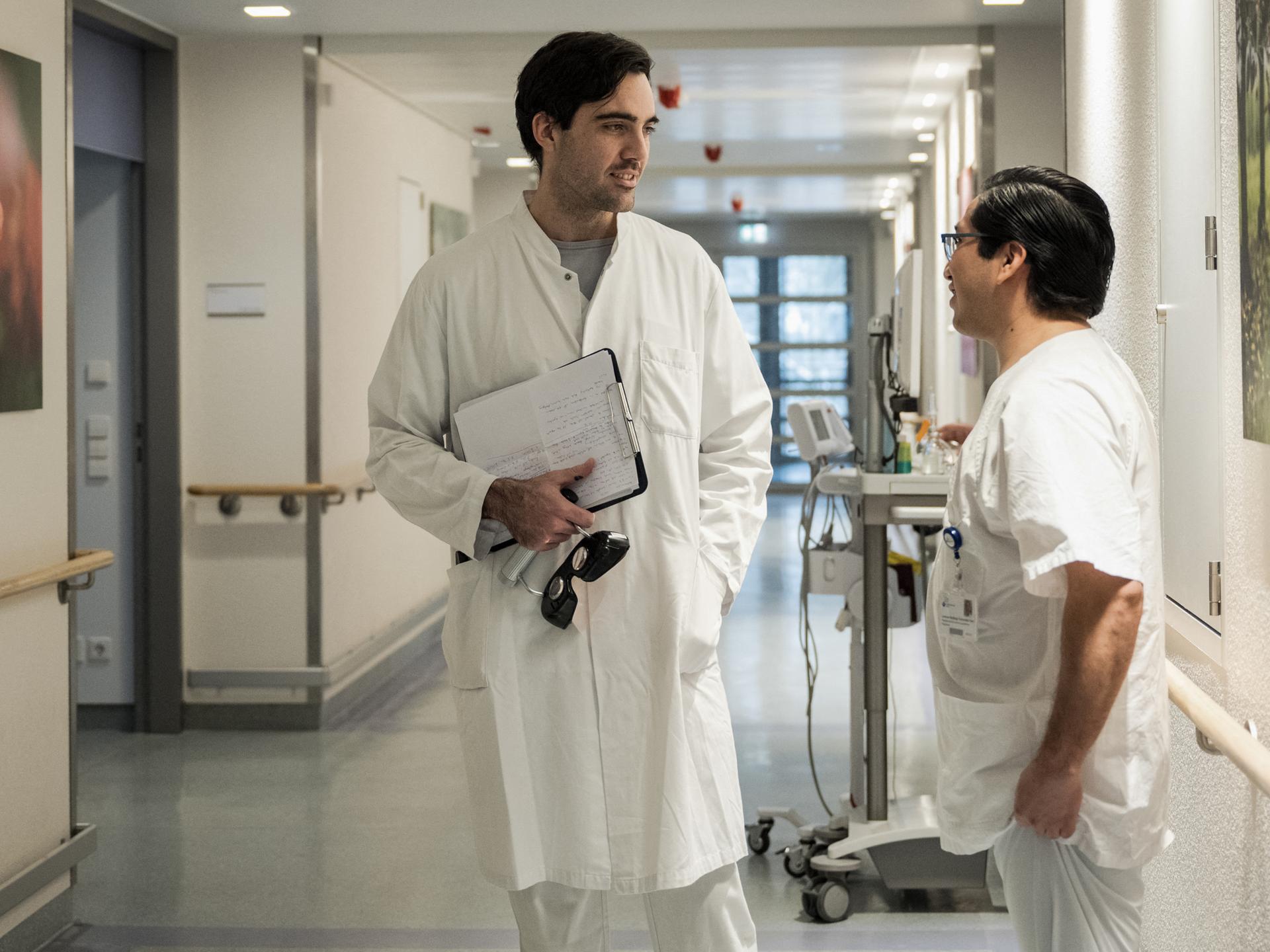 Der mexikanische Arzt und angehende Neurologe Mario de la Piedra Walter (links) und der Krankenpfleger Lorenzo Santiago Fernandez Yam aus Mexiko unterhalten sich am 13. Februar 2025 in einem Berliner Krankenhaus