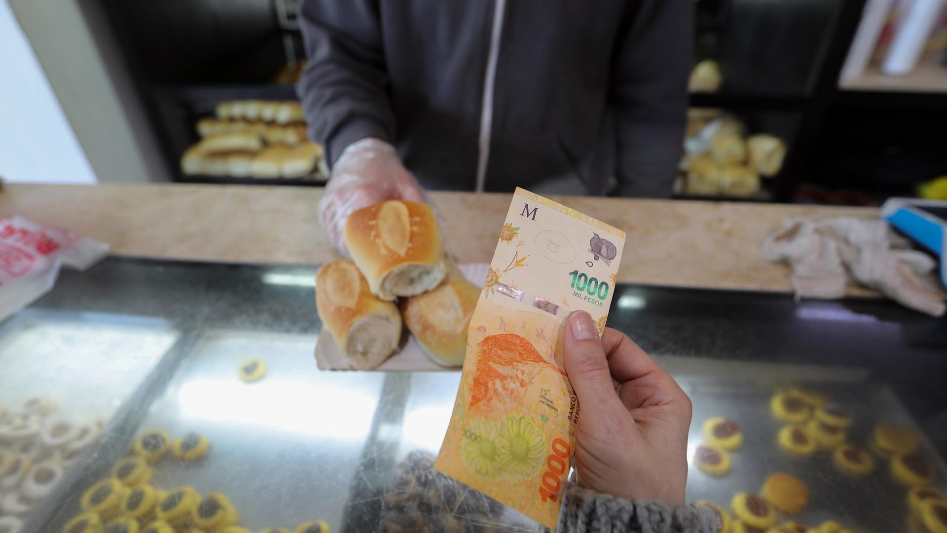 Eine Frau zahlt mit einem 1000-Peso-Schein in einer Bäckerei.