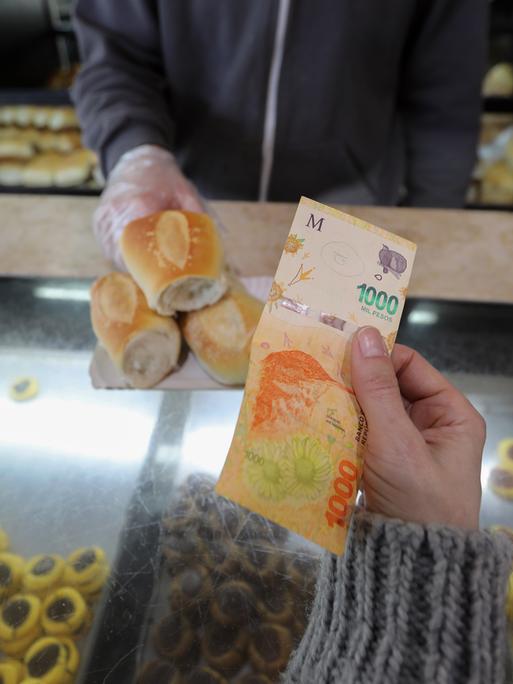 Eine Frau zahlt mit einem 1000-Peso-Schein in einer Bäckerei. (zu dpa «Inflationsrate in Argentinien steigt auf 71 Prozent») Eine Frau zahlt mit einem 1000-Peso-Schein in einer Bäckerei. (zu dpa «Inflationsrate in Argentinien steigt auf 71 Prozent»)