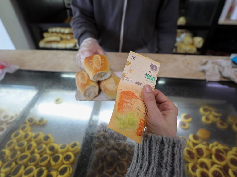 Eine Frau zahlt mit einem 1000-Peso-Schein in einer Bäckerei. (zu dpa «Inflationsrate in Argentinien steigt auf 71 Prozent») Eine Frau zahlt mit einem 1000-Peso-Schein in einer Bäckerei. (zu dpa «Inflationsrate in Argentinien steigt auf 71 Prozent»)