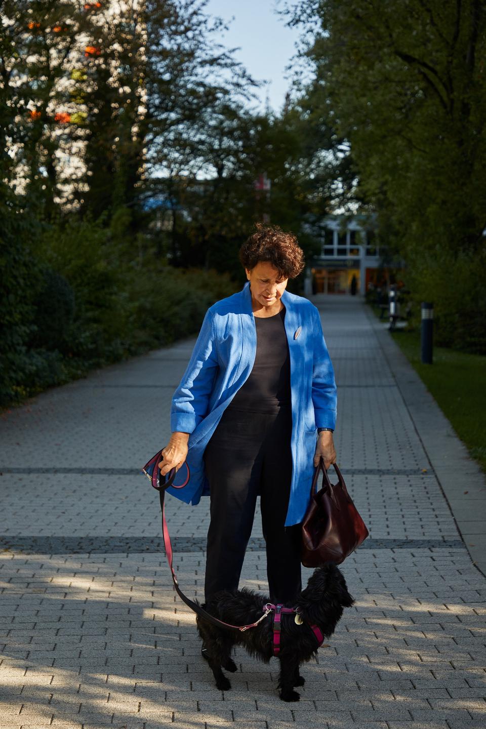 Die Finanzberaterin Hilma Sick in blauer Jacke mit einem Hund an der Leine.