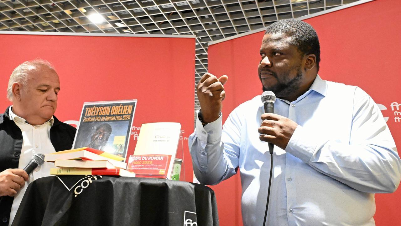Der kanadisch-haitianische Autor Thélyson Orélien steht auf einer Bühne und spricht in ein Mikrofon.