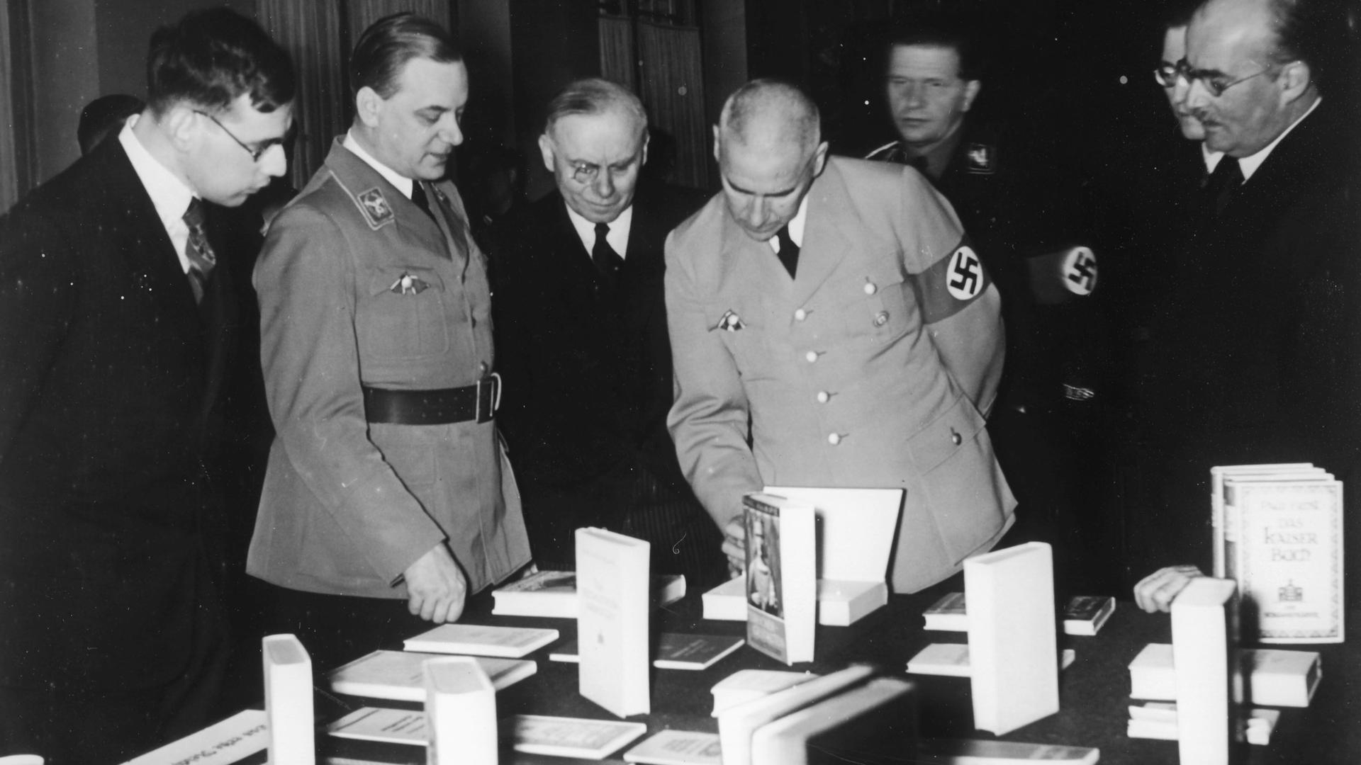 Alfred Rosenberg, links in Uniform, Leiter des außenpolitischen Amtes der NSDAP, eröffnet die Ausstellung "Das politische Deutschland" in Berlin 1936. Reichsminister Wilhelm Frick besucht die Ausstellung.