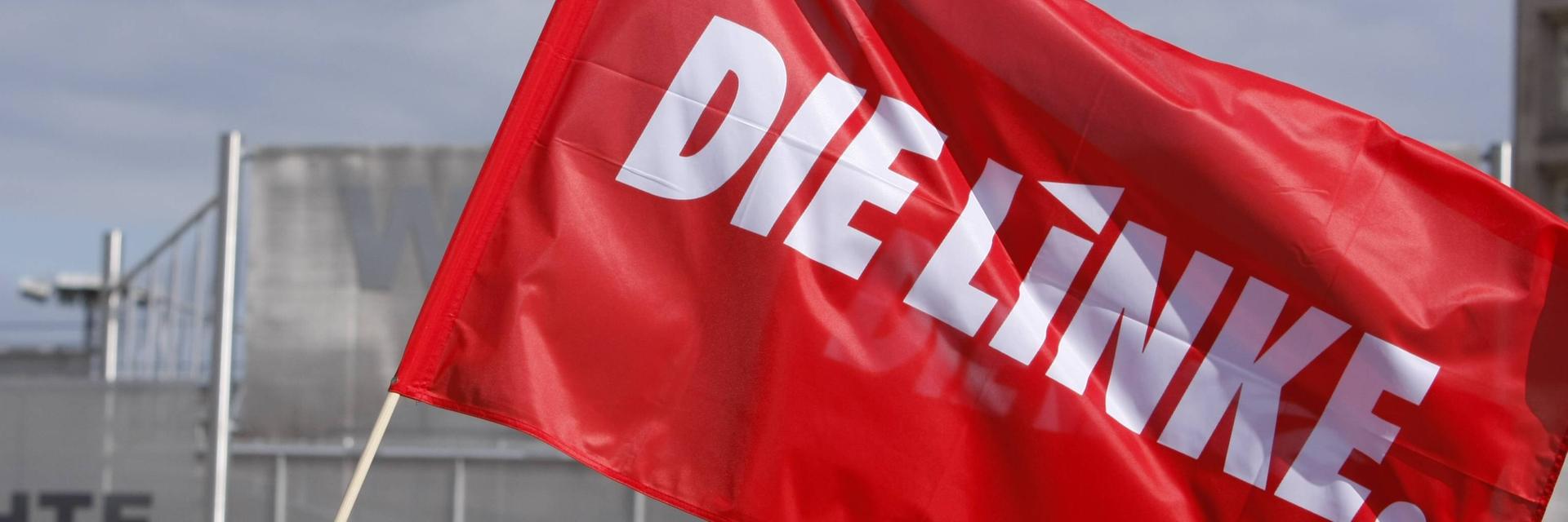 Eine Fahne mit Aufschrift "Die Linke" weht im Wind.