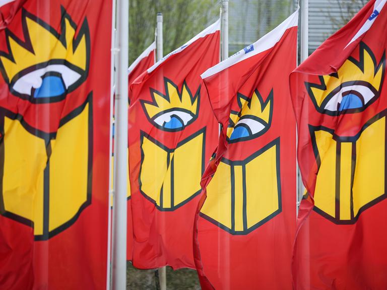 Sachsen, Leipzig: Fahnen mit dem Logo der Buchmesse wehen auf dem Messeglände.