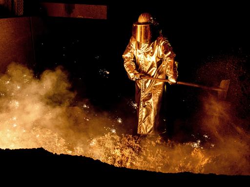 Ein Mitarbeiter schaufelt im Stahlwerk der Salzgitter AG Sand in die Abstichrinne am Hochofen.