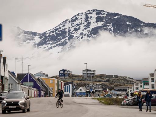 Panorama-Ansicht eines Dorfs in Grönland mit imposantem Berg dahinter Panorama-Ansicht eines Dorfs in Grönland mit imposantem Berg dahinter