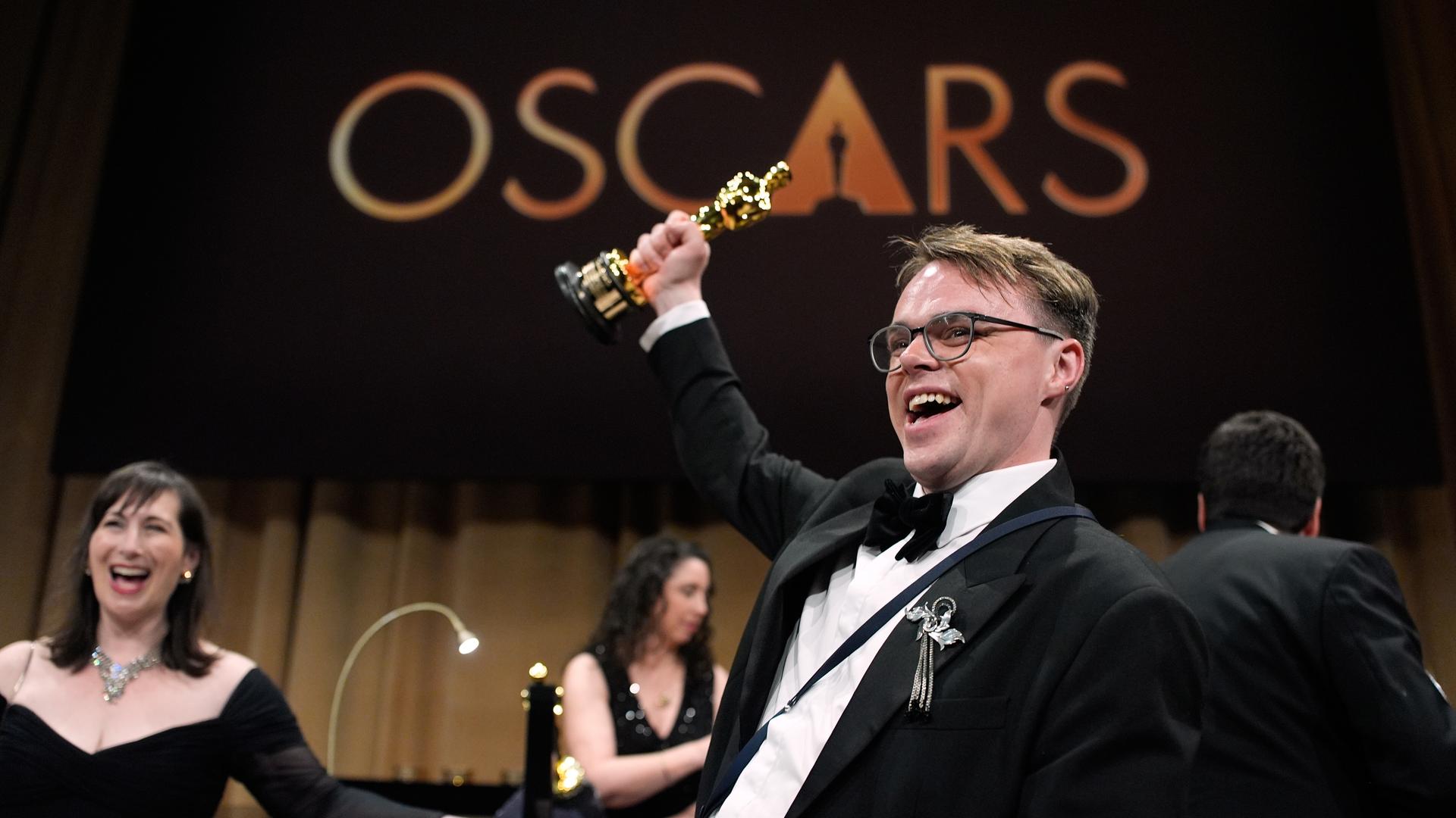 Regisseur Pawel Talankin hält den Oscar mit gestrecktem Arm in die Luft und freut sich über die Auszeichnung für seinen Dokumentarfilm "Ein Nobody gegen Putin".