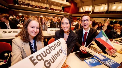 Drei Schüler lachen bei der internationalen Schülerkonferenz Oldenburg Model United Nations in der Weser-Ems-Halle in die Kamera