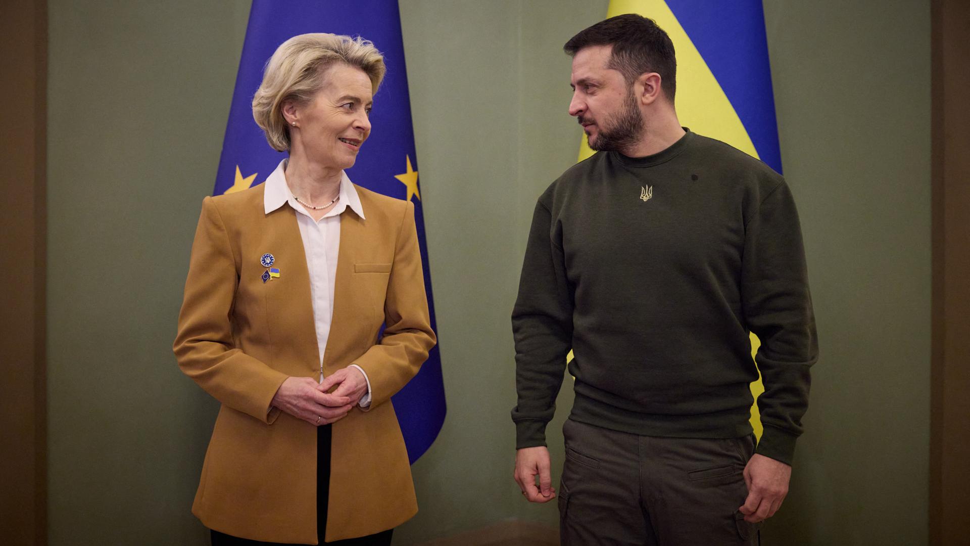 EU-Kommissionspräsidentin Ursula von der Leyen und der ukrainische Präsident Wolodymyr Selenskyj stehen nebeneinander und schauen sich an.