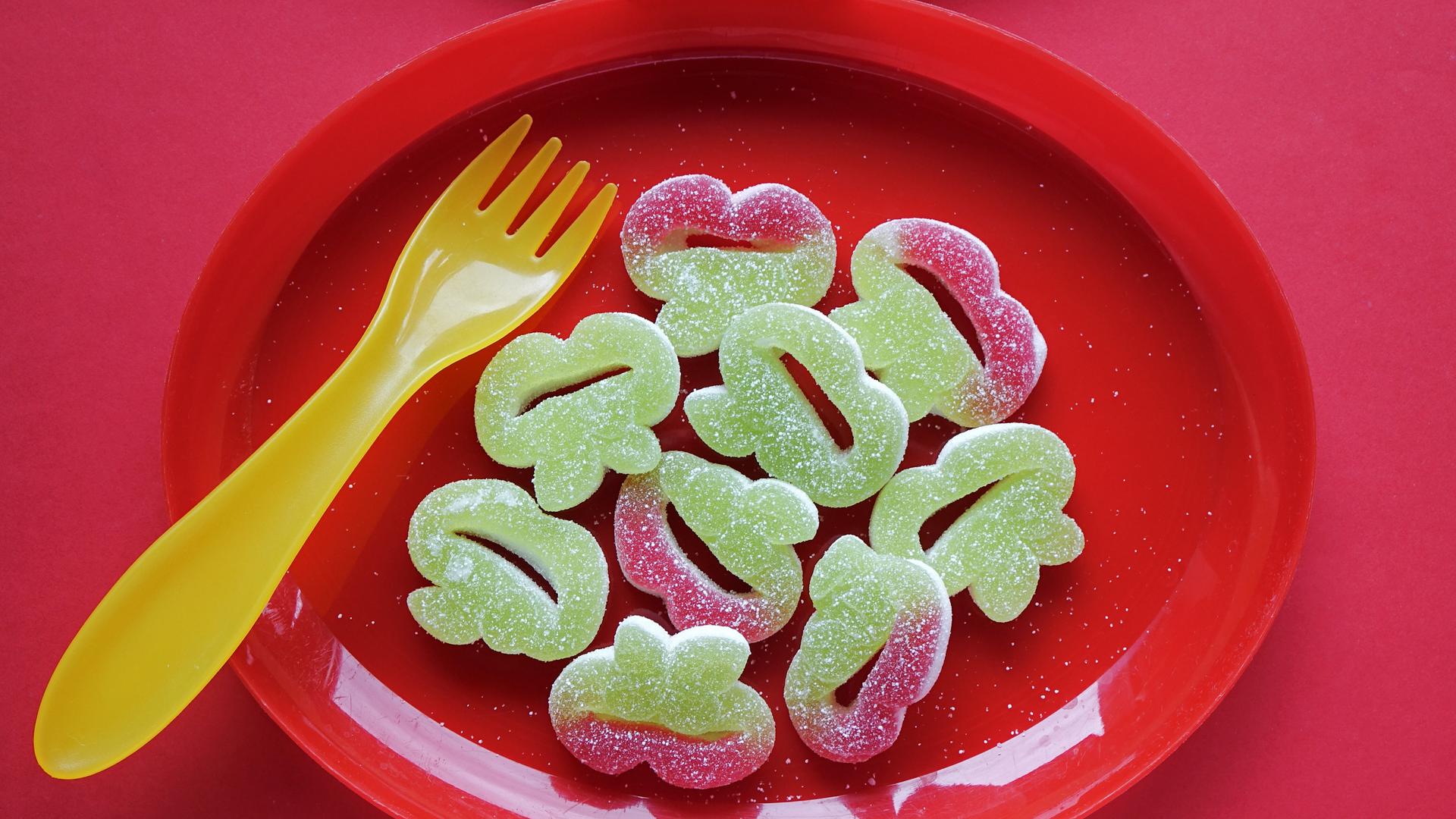 Grüner Fruchtgummi auf einem roten Teller