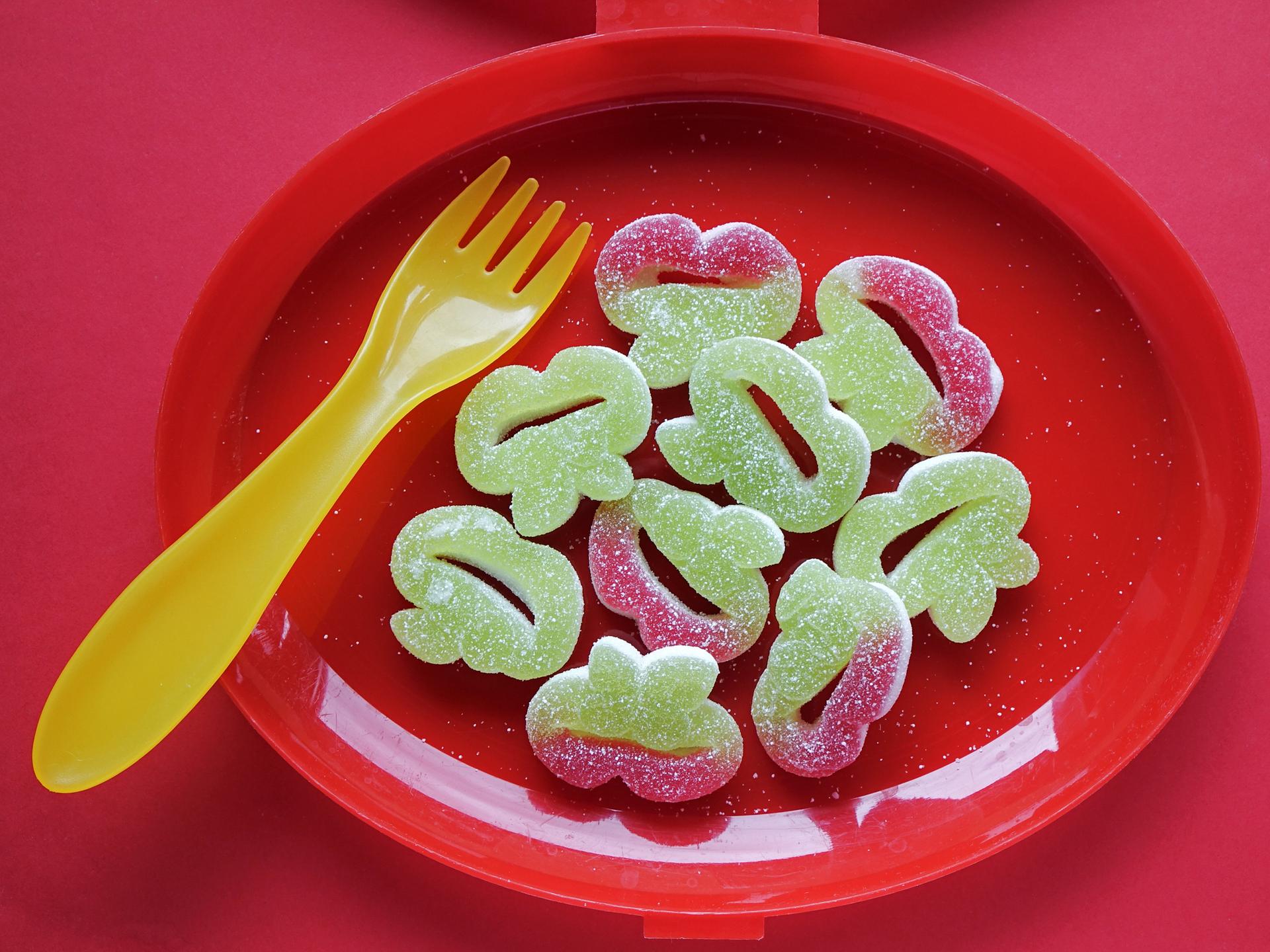 Grüner Fruchtgummi auf einem roten Teller