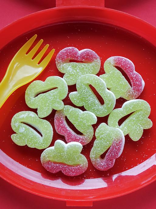 Grüner Fruchtgummi auf einem roten Teller