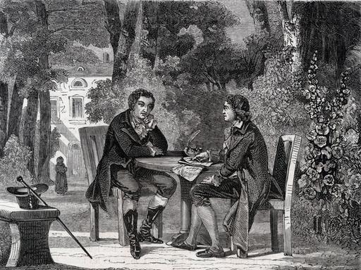 Historische Druckgrafik von 1880: Friedrich Schiller und Johann Wolfgang von Goethe sitzen im Garten an einem Tisch. Um sie herum stehen Bäume,  im Hintergrund ist ein Haus zu erkennen.