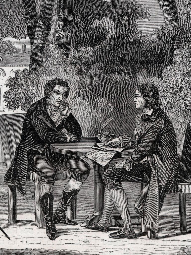 Historische Druckgrafik von 1880: Friedrich Schiller und Johann Wolfgang von Goethe sitzen im Garten an einem Tisch. Um sie herum stehen Bäume,  im Hintergrund ist ein Haus zu erkennen.