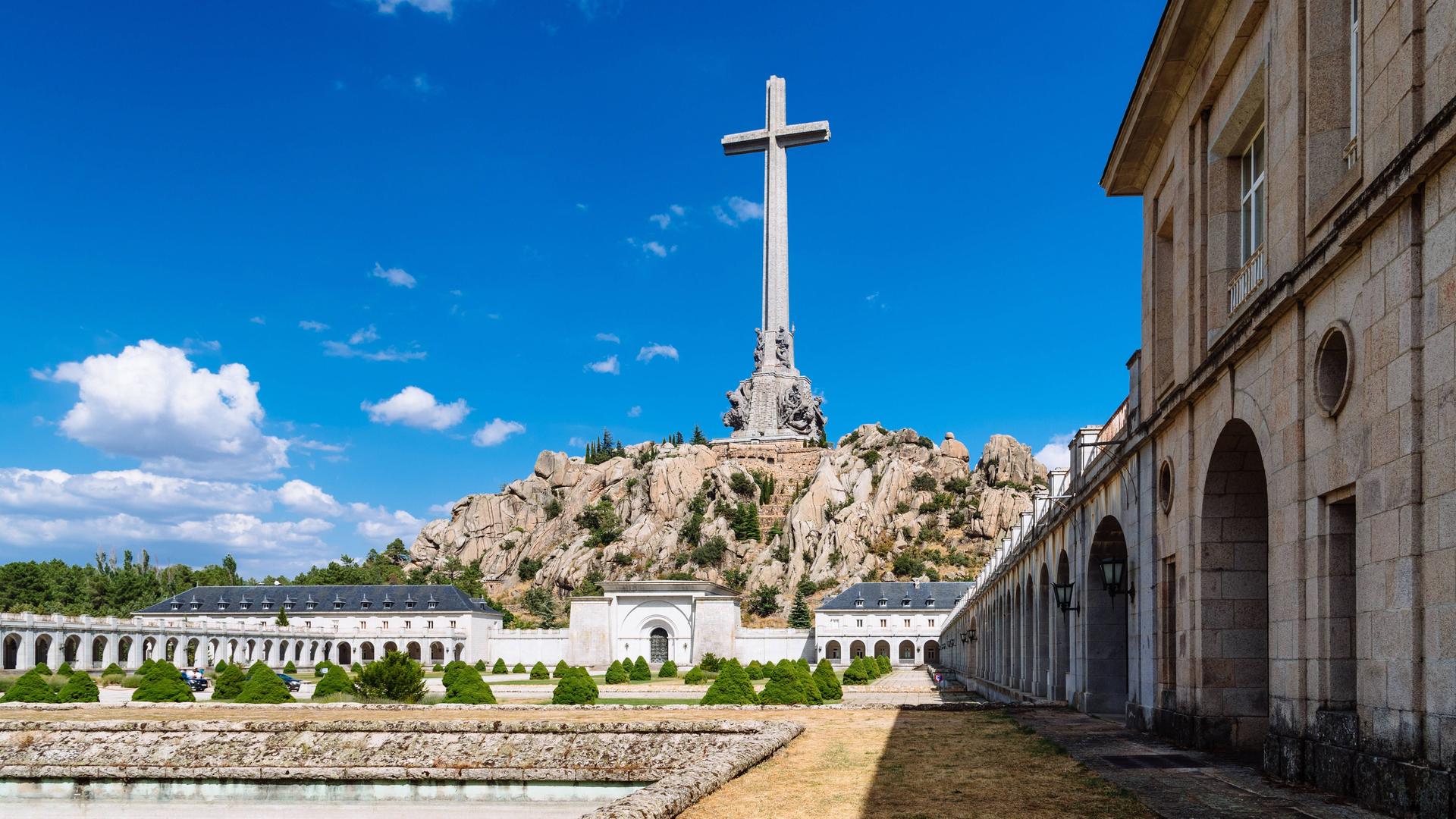 Eine Kirche und ein riesiges Kreuz auf einer Felsenanhöhe in Valle de Los Caidos in Spanien. Neben der Kirche in Mausoleum.