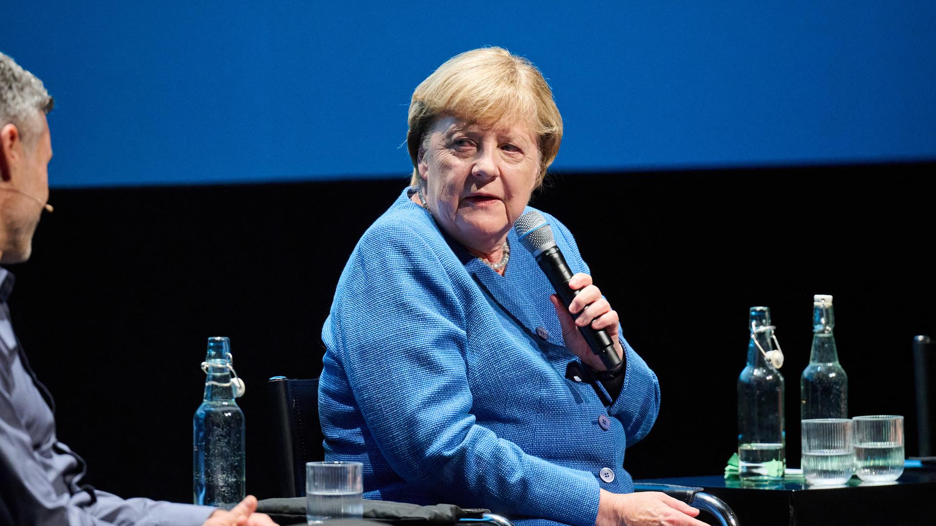 Die ehmalige Bundeskanzlerin Angela Merkel sitzt auf einem Podium im Haus der Berliner Festspiele und spricht in ein Mikrofon. Die ehmalige Bundeskanzlerin Angela Merkel sitzt auf einem Podium im Haus der Berliner Festspiele und spricht in ein Mikrofon.