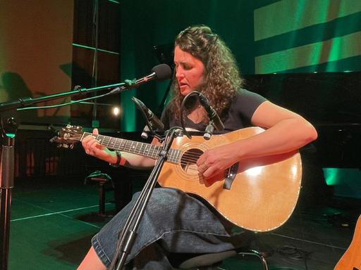 Michelle Willis sitzt mit ihrer birnenförmigen Gitarre im Kammermusiksaal von Deutschlandfunk in Köln.