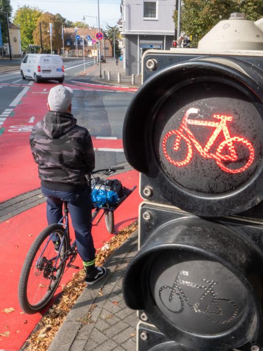 Ein Radfahrer wartet auf der Veloroute in Hannover, während die Ampel Rot anzeigt.