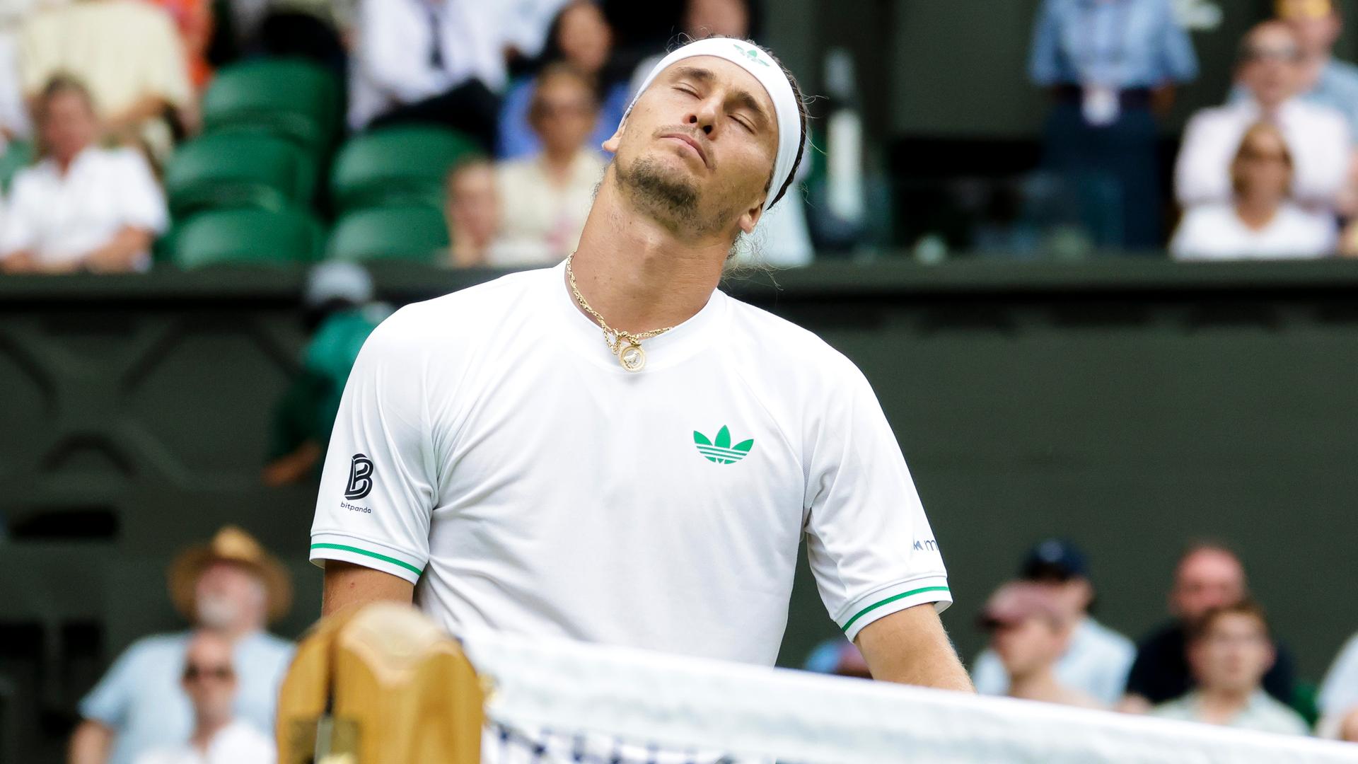 Zverev im weißen Shirt schließt enttäuscht die Augen. Dahinter eine vollbesetzte Zuschauertribüne . Zverev im weißen Shirt schließt enttäuscht die Augen. Dahinter eine vollbesetzte Zuschauertribüne .