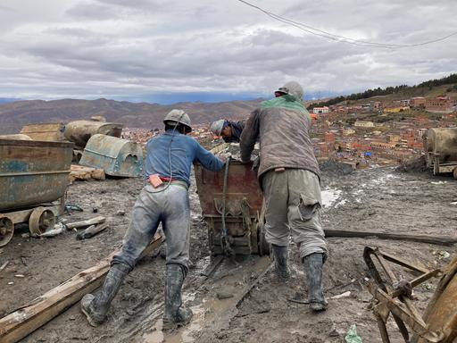 Bergarbeiter schieben einen Transportwagen