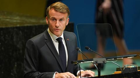 Der französische Präsident Macron steht an einem Rednerpult. Er trägt einen dunklen Anzug.