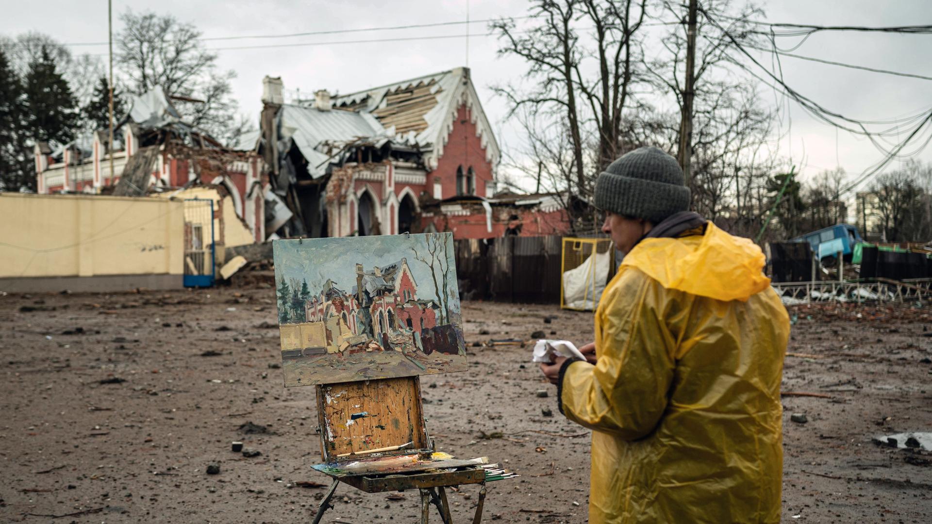 Der lokale Künstler Viktor Onyshchenko malt die zerstörte Bibliothek in Tschernihiw.
