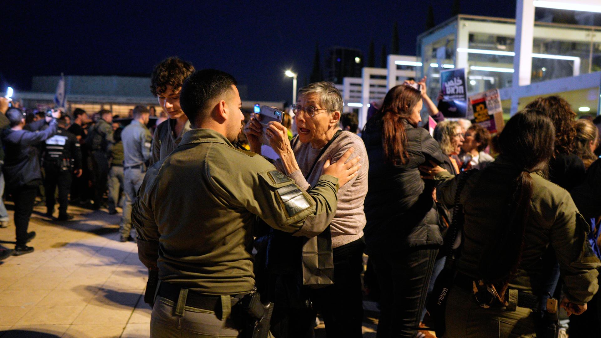 Bei Protesten in Tel Aviv diskutiert ein Demonstrant mit einem Sicherheitsbeamten.