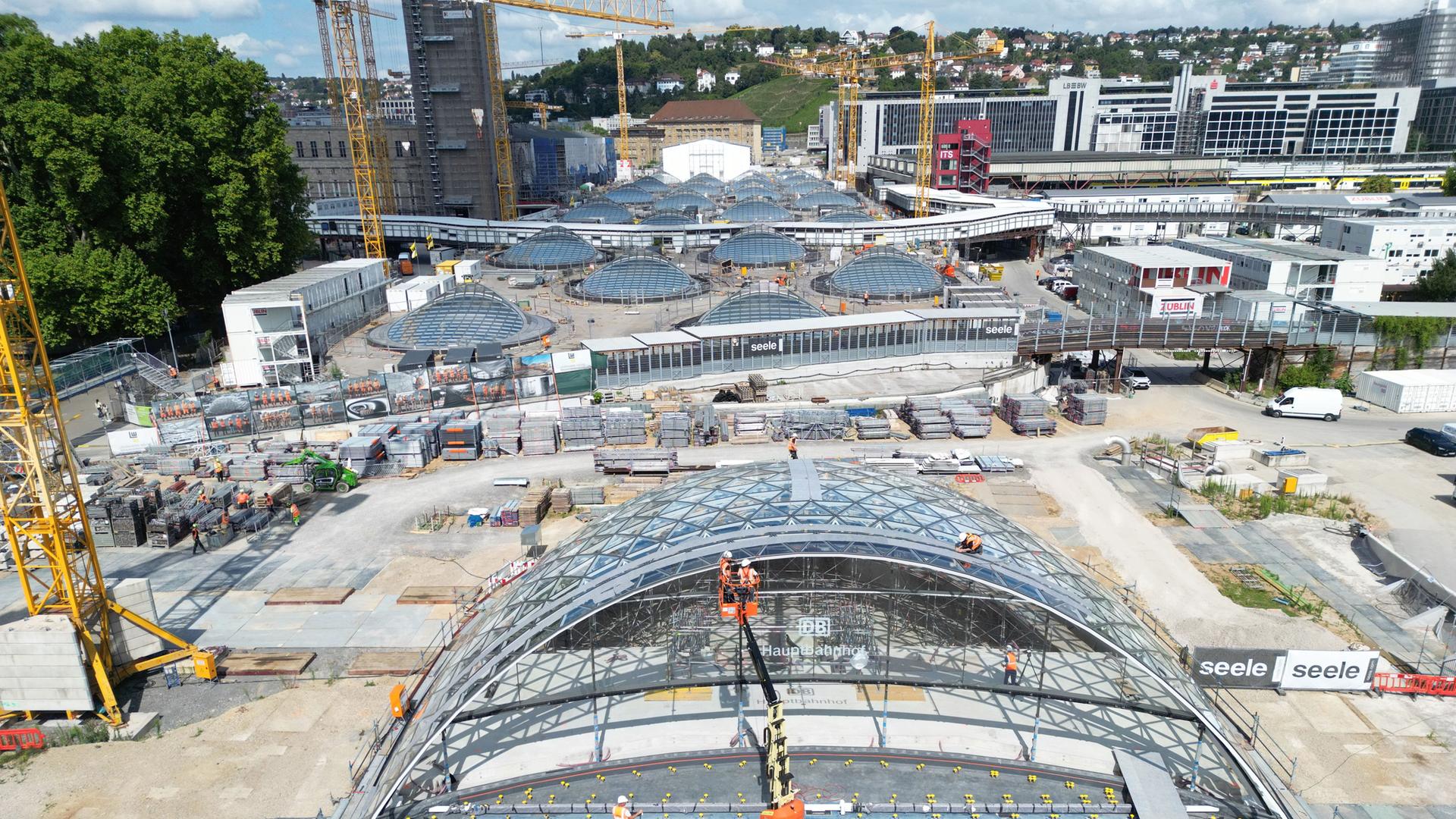 Bauarbeiter arbeiten an einem weitgehend fertiggestellten Eingangsportal für den neuen Tiefbahnhof im Rahmen des milliardenschweren Bahnprojekts Stuttgart 21.