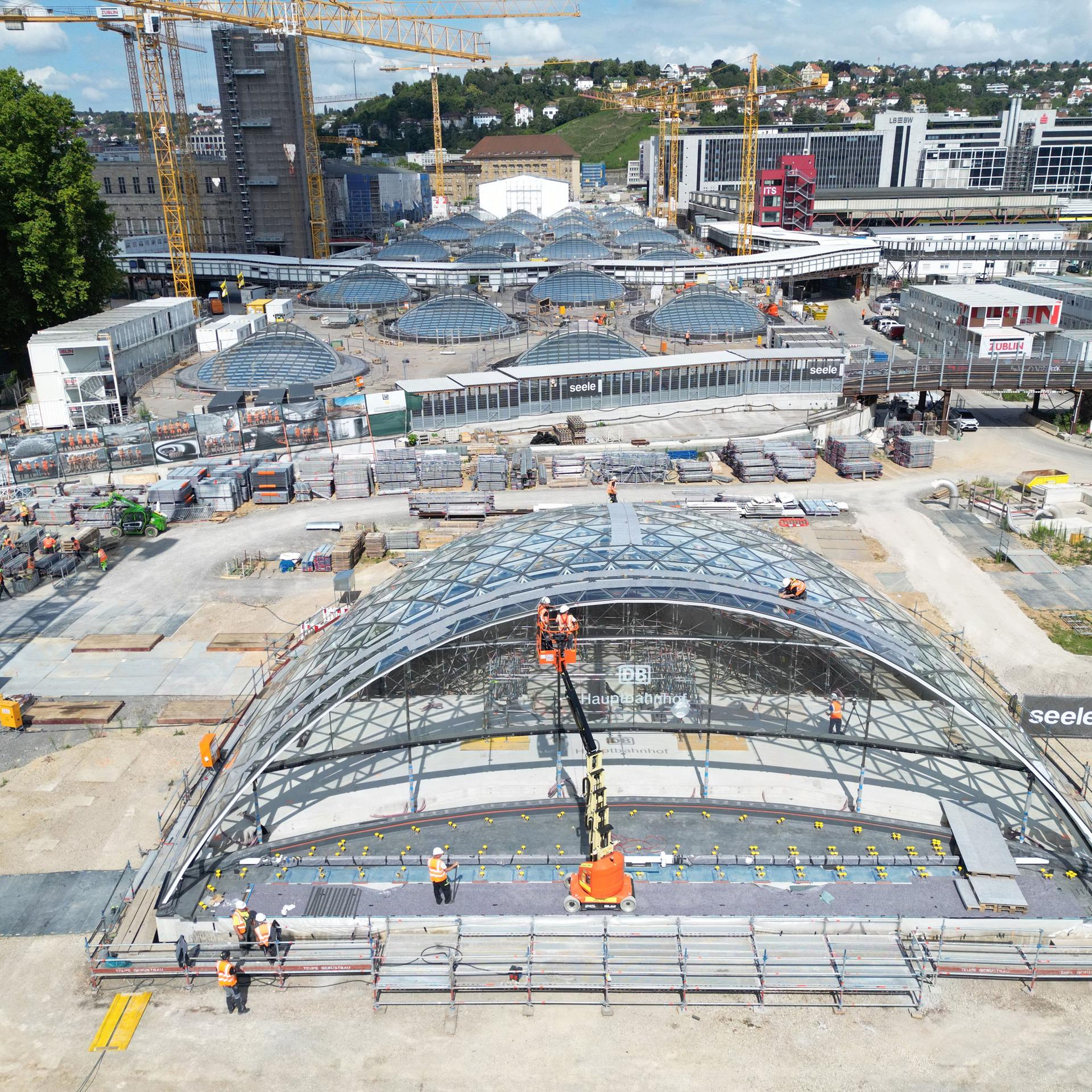 Bauarbeiter arbeiten an einem weitgehend fertiggestellten Eingangsportal für den neuen Tiefbahnhof im Rahmen des milliardenschweren Bahnprojekts Stuttgart 21.