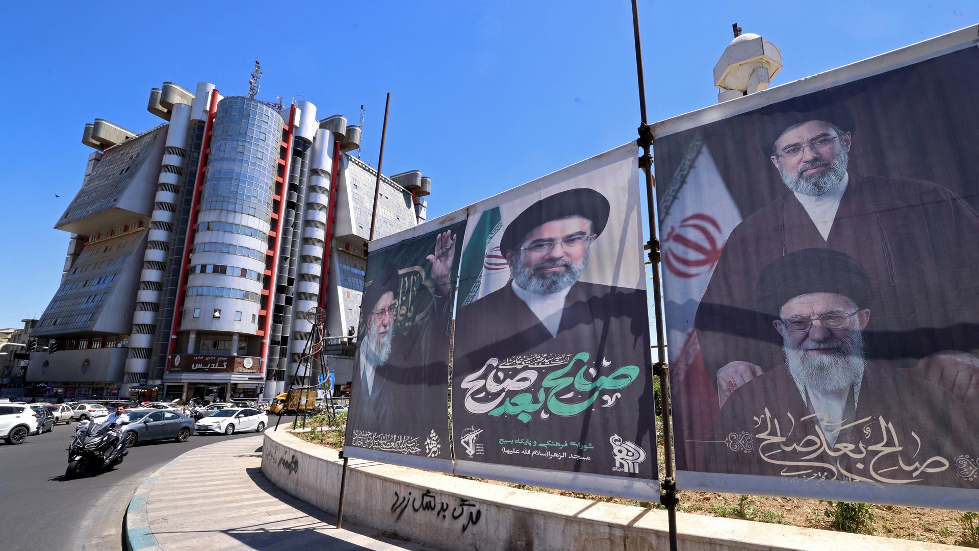 Banner an einem Platz in der iranischen Hauptstadt Teheran. Abgebildet sind darauf der getötete oberste Führer des Iran, Ayatollah Ali Khamenei, sowie sein Sohn Mojataba Khamenei.