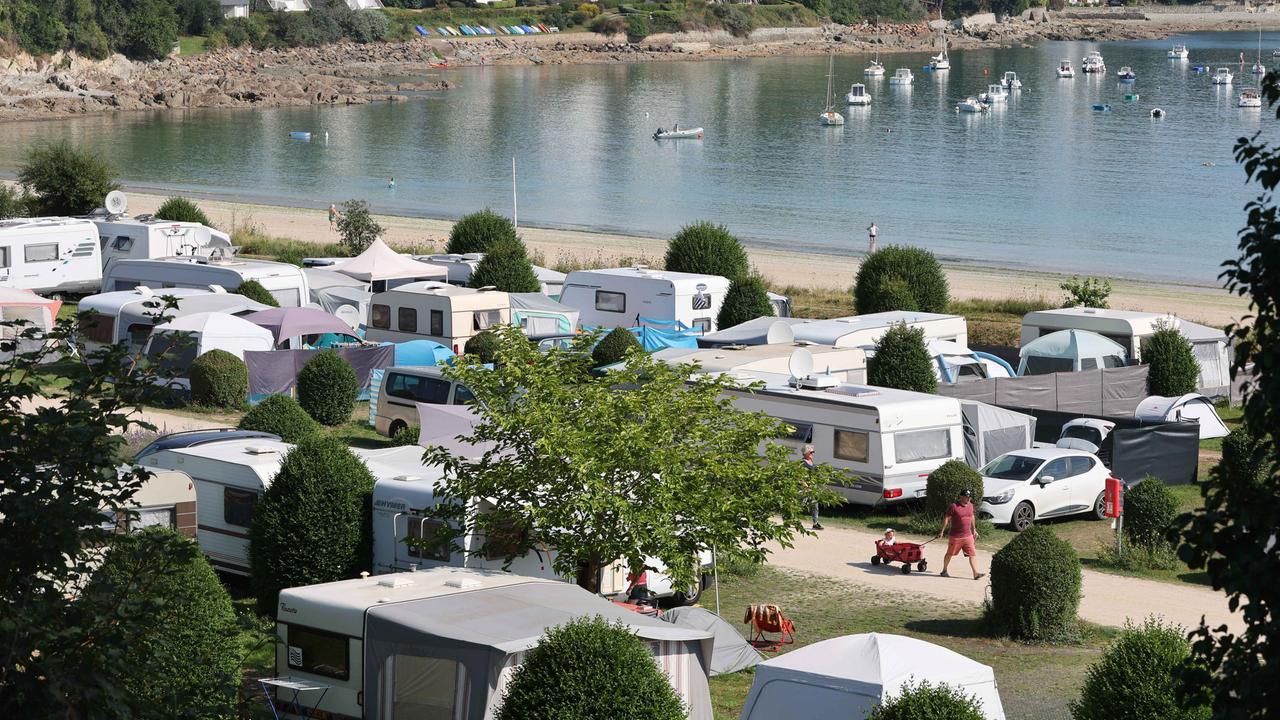 Städtischer Campingplatz mit Zelten und Wohnmobilen am Ende der Bucht von Locquirec in der Bretagne (Frankreich) direkt am Strand. 