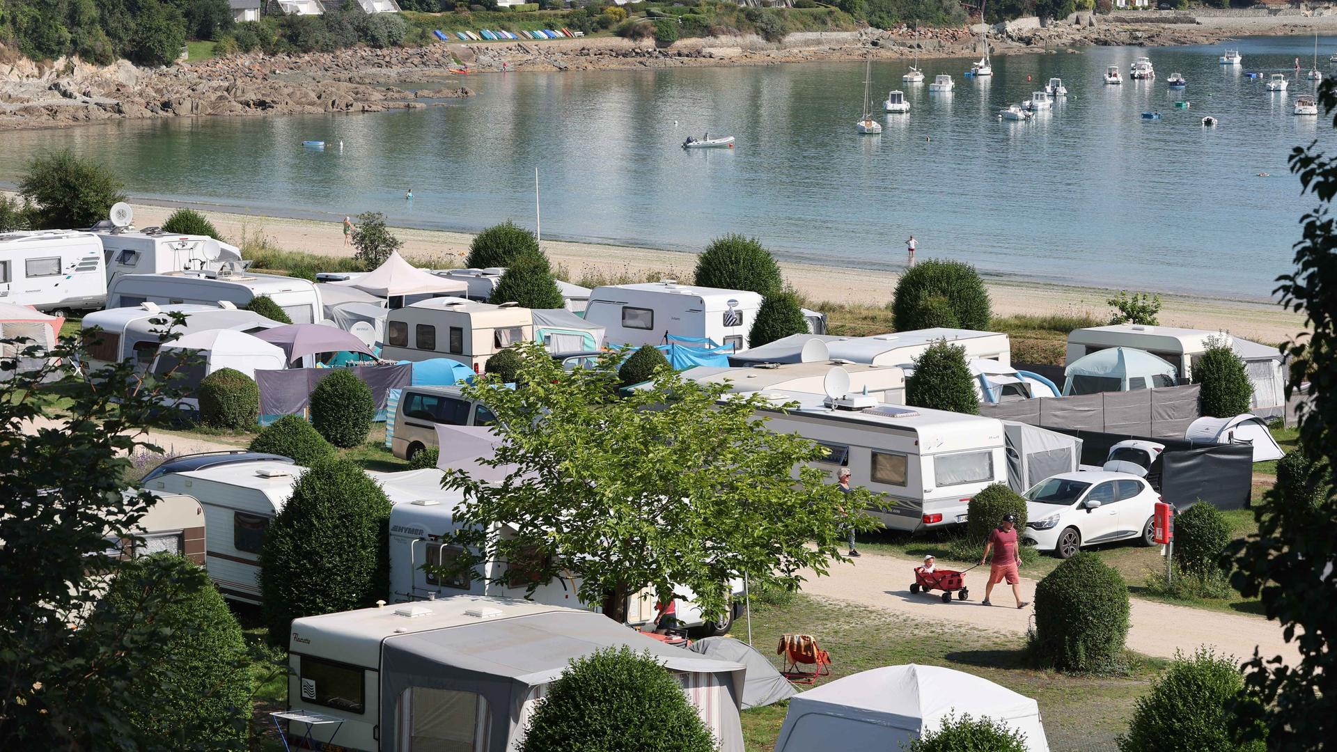 Städtischer Campingplatz mit Zelten und Wohnmobilen am Ende der Bucht von Locquirec in der Bretagne (Frankreich) direkt am Strand. 