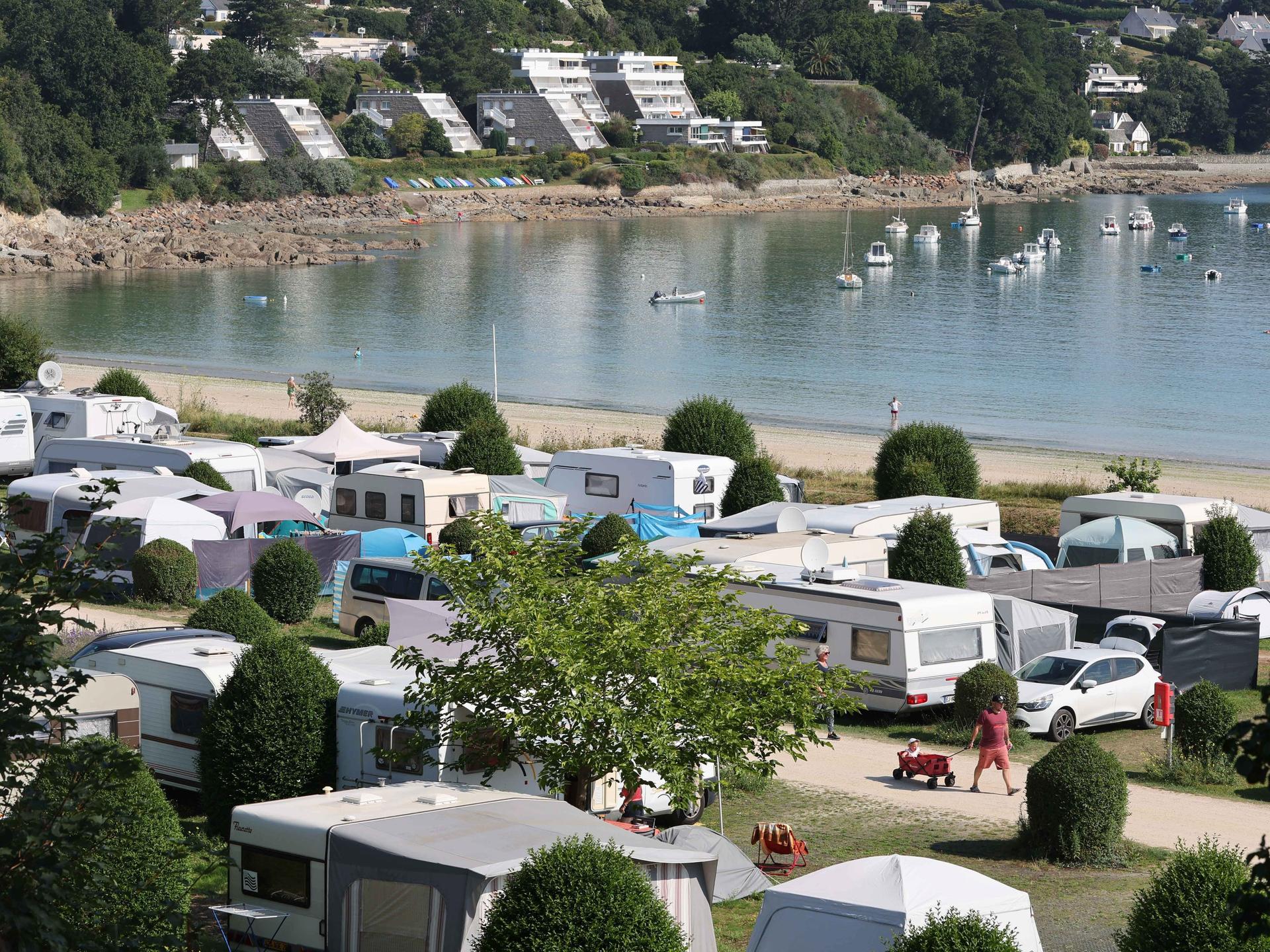 Städtischer Campingplatz mit Zelten und Wohnmobilen am Ende der Bucht von Locquirec in der Bretagne (Frankreich) direkt am Strand. 