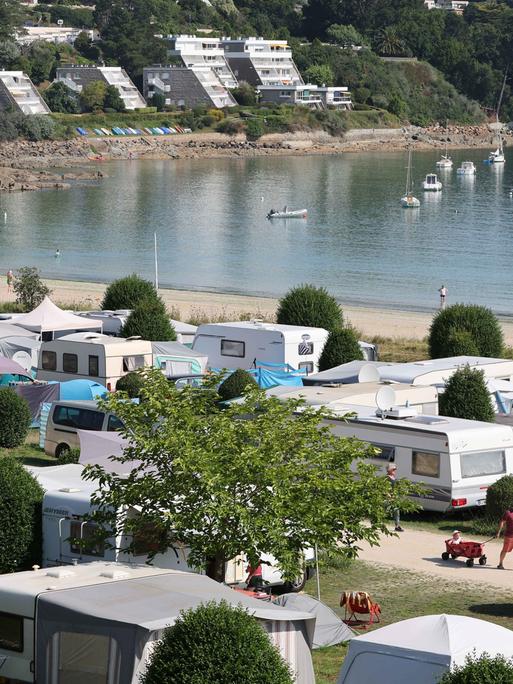 Städtischer Campingplatz mit Zelten und Wohnmobilen am Ende der Bucht von Locquirec in der Bretagne (Frankreich) direkt am Strand. 