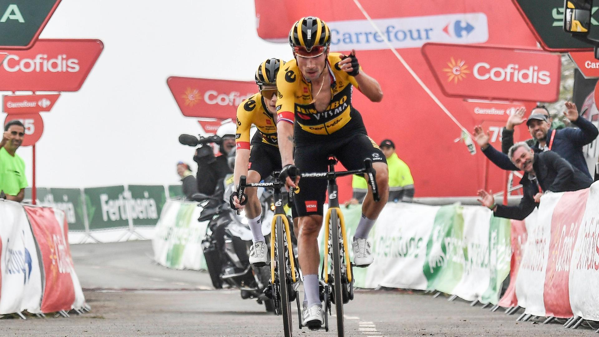 Primoz Roglic fährt ins Ziel, hinter ihm ein weiterer Radrennfahrer sowie ein Motorrad. Primoz Roglic fährt ins Ziel, hinter ihm ein weiterer Radrennfahrer sowie ein Motorrad.