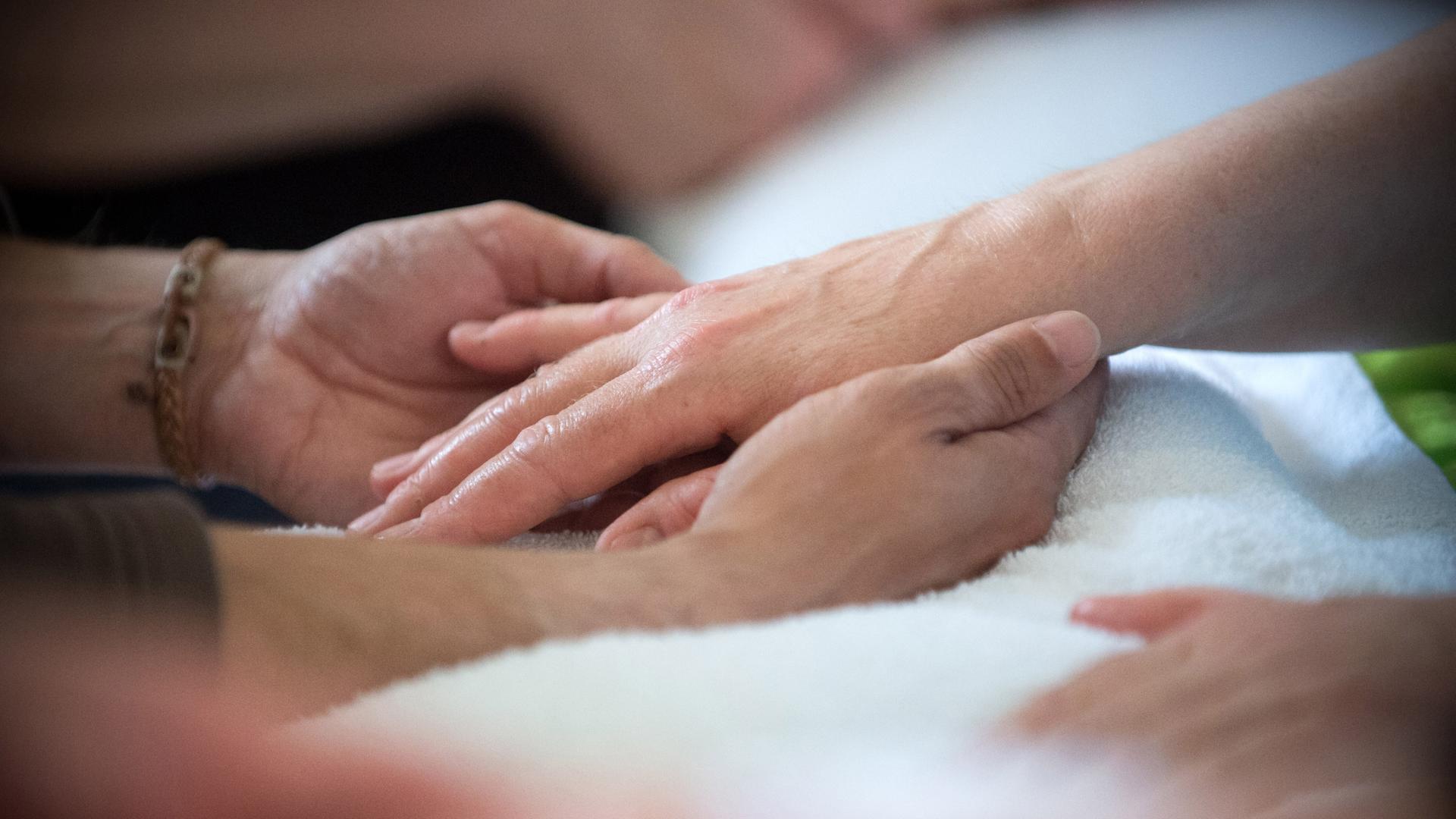 Sich berührende Hände auf einer Pflegestation im brandenburgischen Bernau