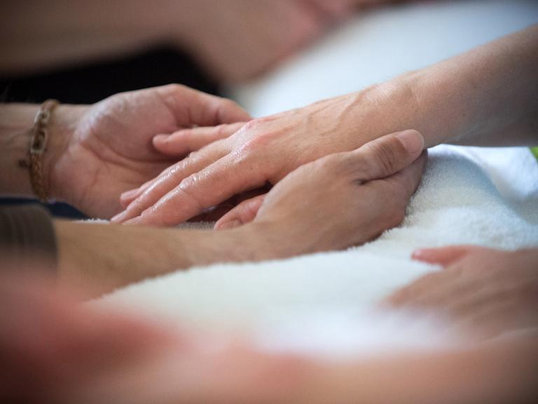 Sich berührende Hände auf einer Pflegestation im brandenburgischen Bernau